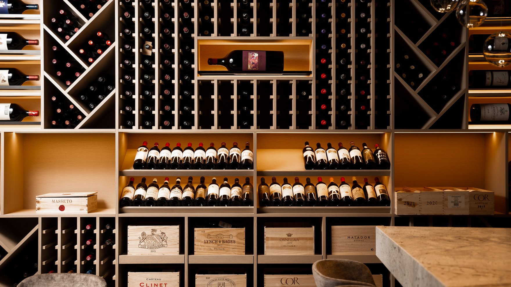 Exzellent essen in diesem Restaurant in Sterzing Weinregal mit vielen Flaschen und Holzkisten in einem modernen Weinkeller
