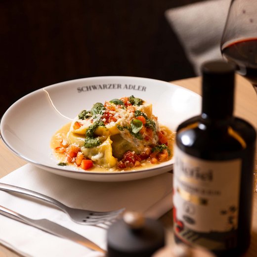 Pamper your palate at this restaurant in Sterzing Plate of stuffed pasta with tomatoes, pesto, and parmesan on a table