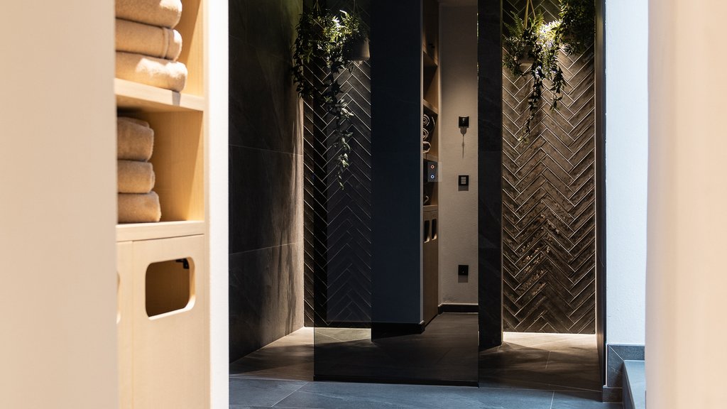 Well-being at the Schwarzer Adler Modern hallway with towel shelves and dark tiled walls