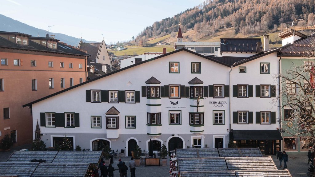 The perfect location for your apartment in Sterzing View of a historic white hotel building with mountains in the background