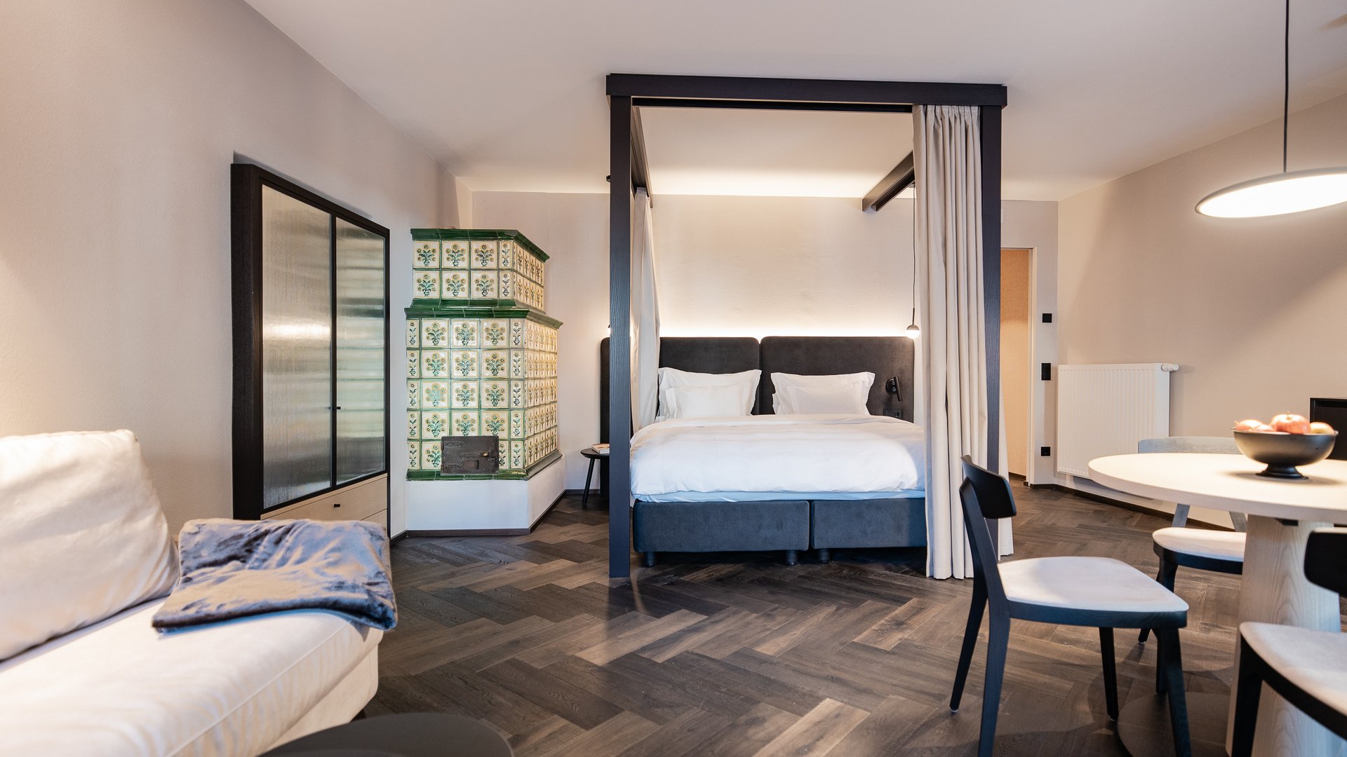 Schwarzer Adler Sterzing: A historic icon. Reinvented. Modern eingerichtetes Wohnzimmer mit Himmelbett, Sofa und Essbereich