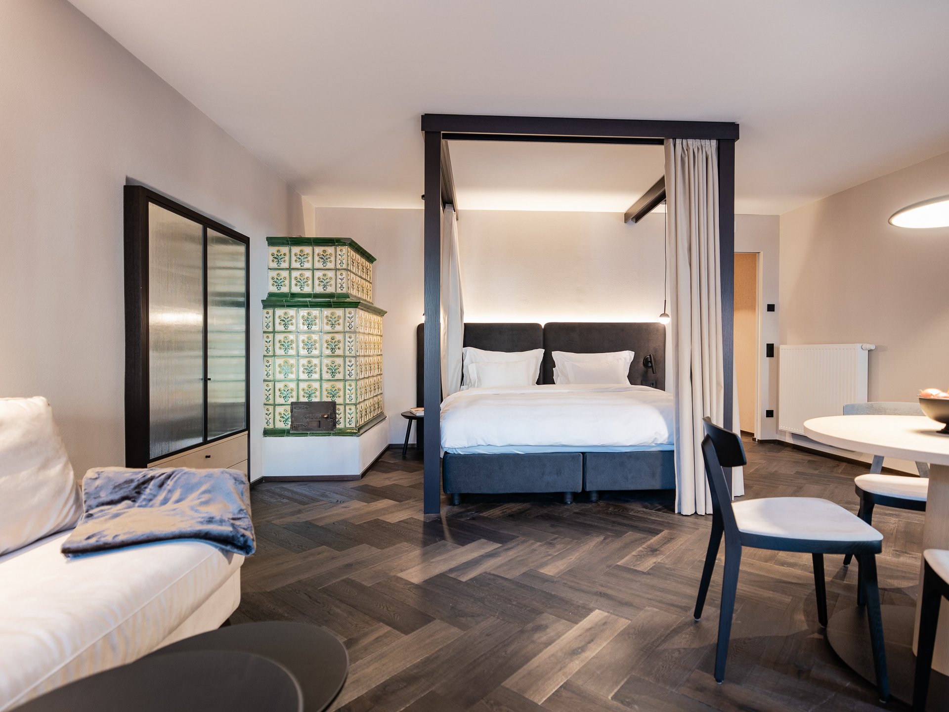 Charmantes Boutique Hotel in Sterzing Modern eingerichtetes Wohnzimmer mit Himmelbett, Sofa und Essbereich