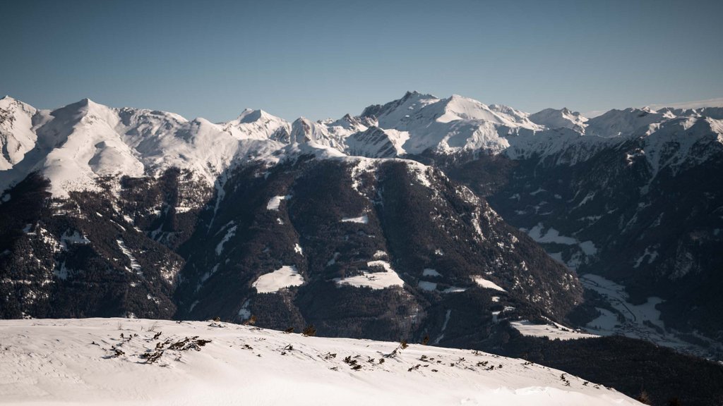 Get your body moving! Snow-covered mountains with clear sky and valleys in the background