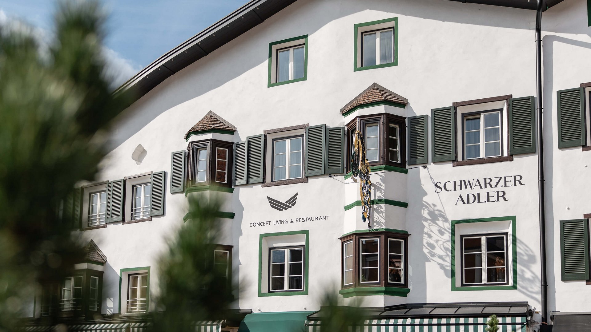 The perfect location for your apartment in Sterzing Exterior view of Schwarzer Adler hotel with green window shutters
