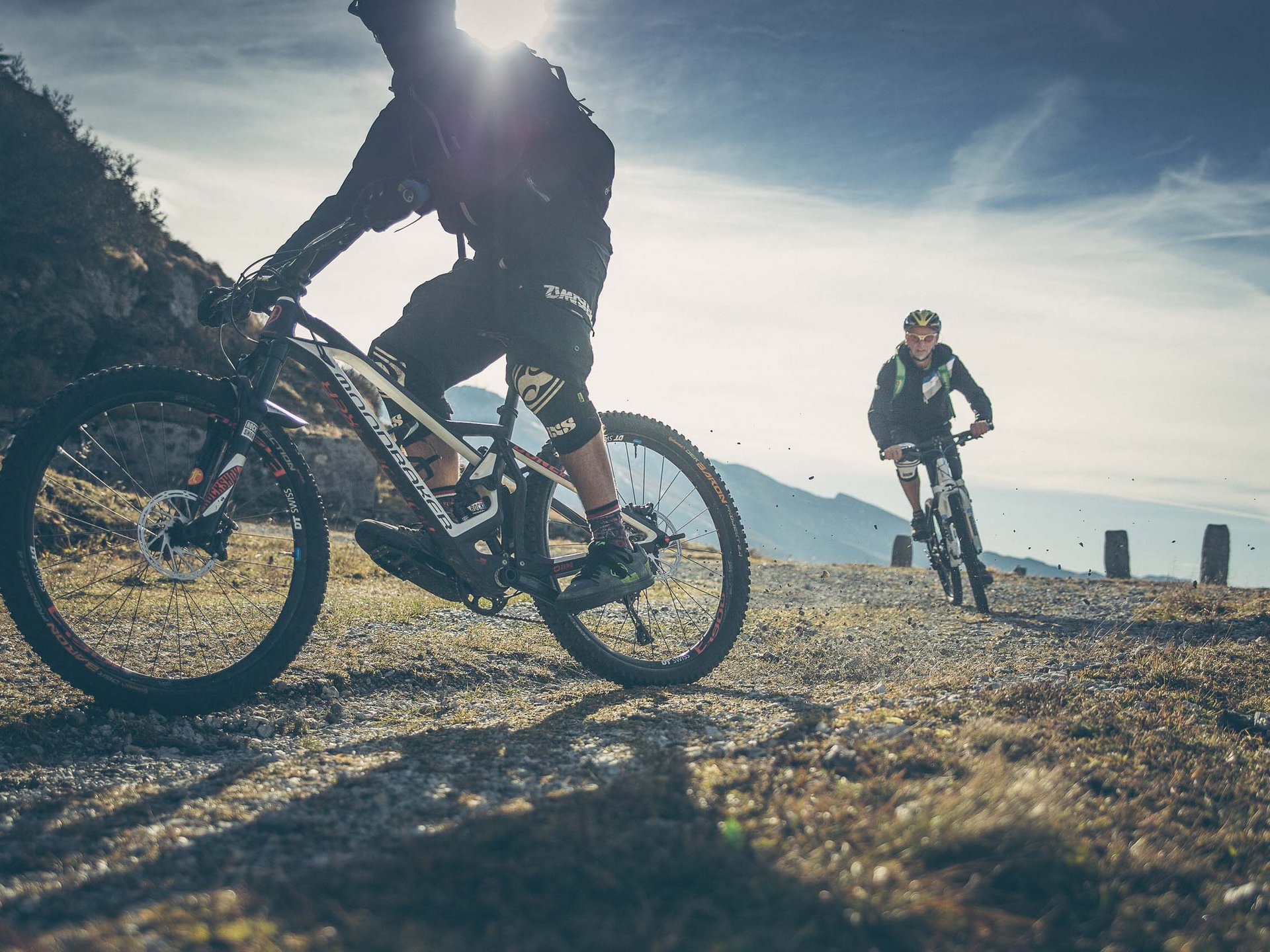 Cooles Rennradhotel in Südtirol Zwei Mountainbiker fahren auf einem bergigen Trail bei sonnigem Wetter