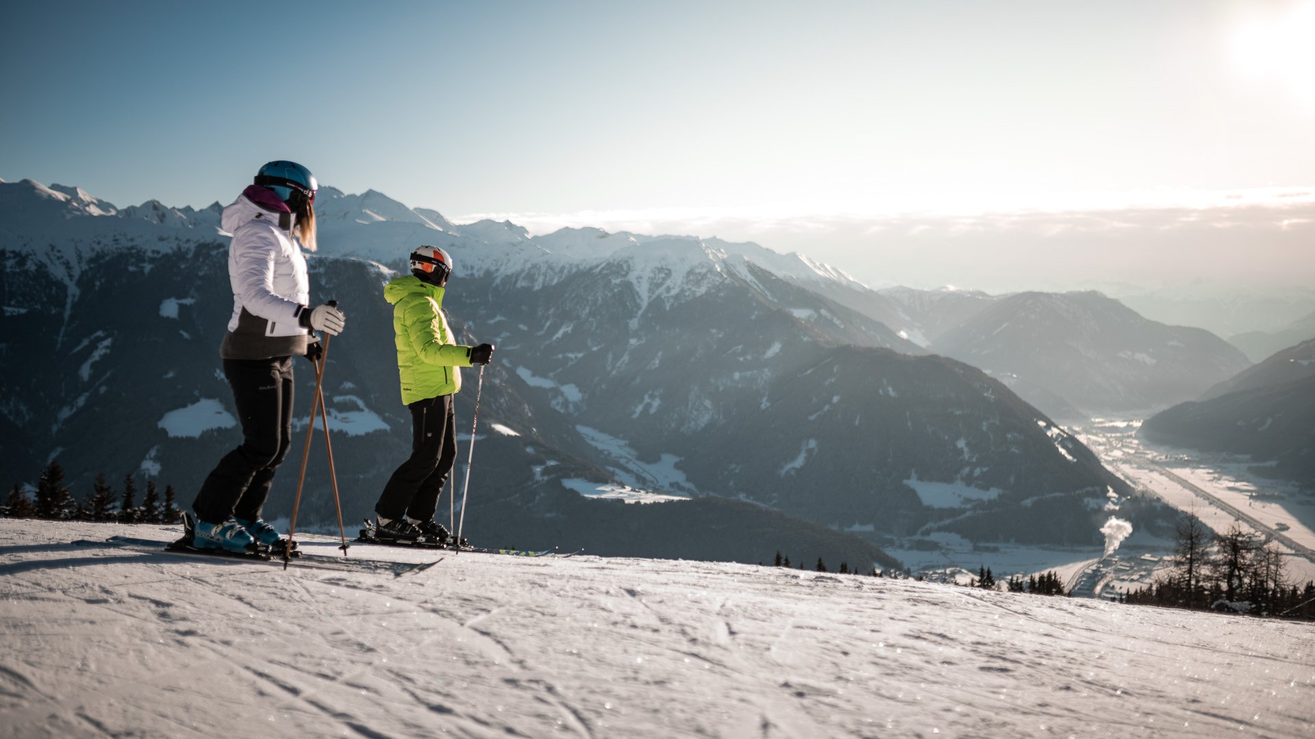 Get your body moving! Two skiers on snow-covered mountain overlooking snowy Alps