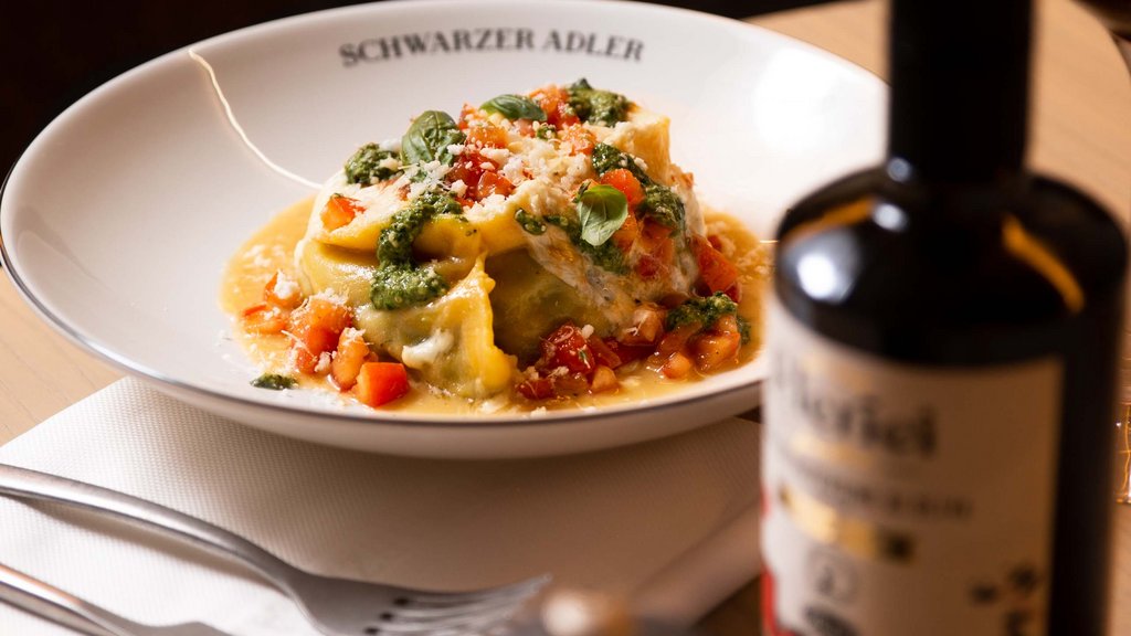 Pamper your palate at this restaurant in Sterzing Plate of tortellini with basil and tomatoes at Schwarzer Adler restaurant