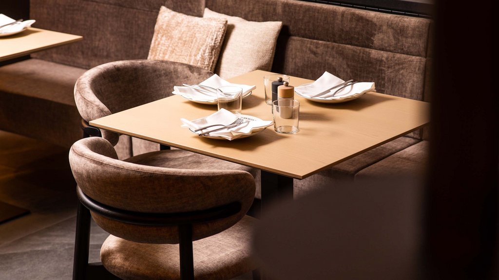 Pamper your palate at this restaurant in Sterzing Cozy restaurant with brown chairs and set table