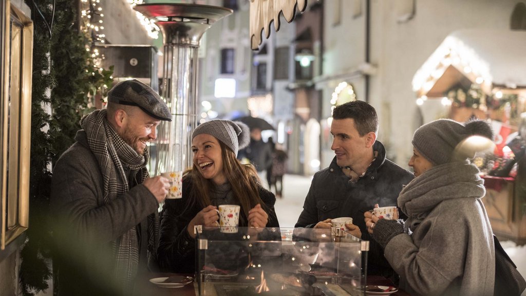 The perfect location for your apartment in Sterzing Four friends drinking hot drinks outdoors in winter at a heated table