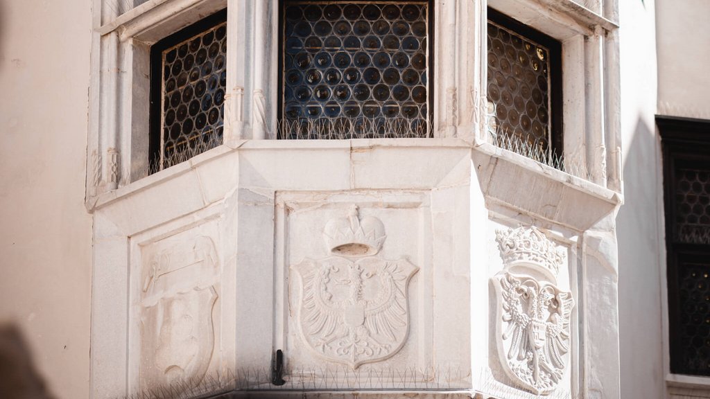 The laid-back town on the Isarco/Eisack river Historic stone carvings and coats of arms on a building corner with windows