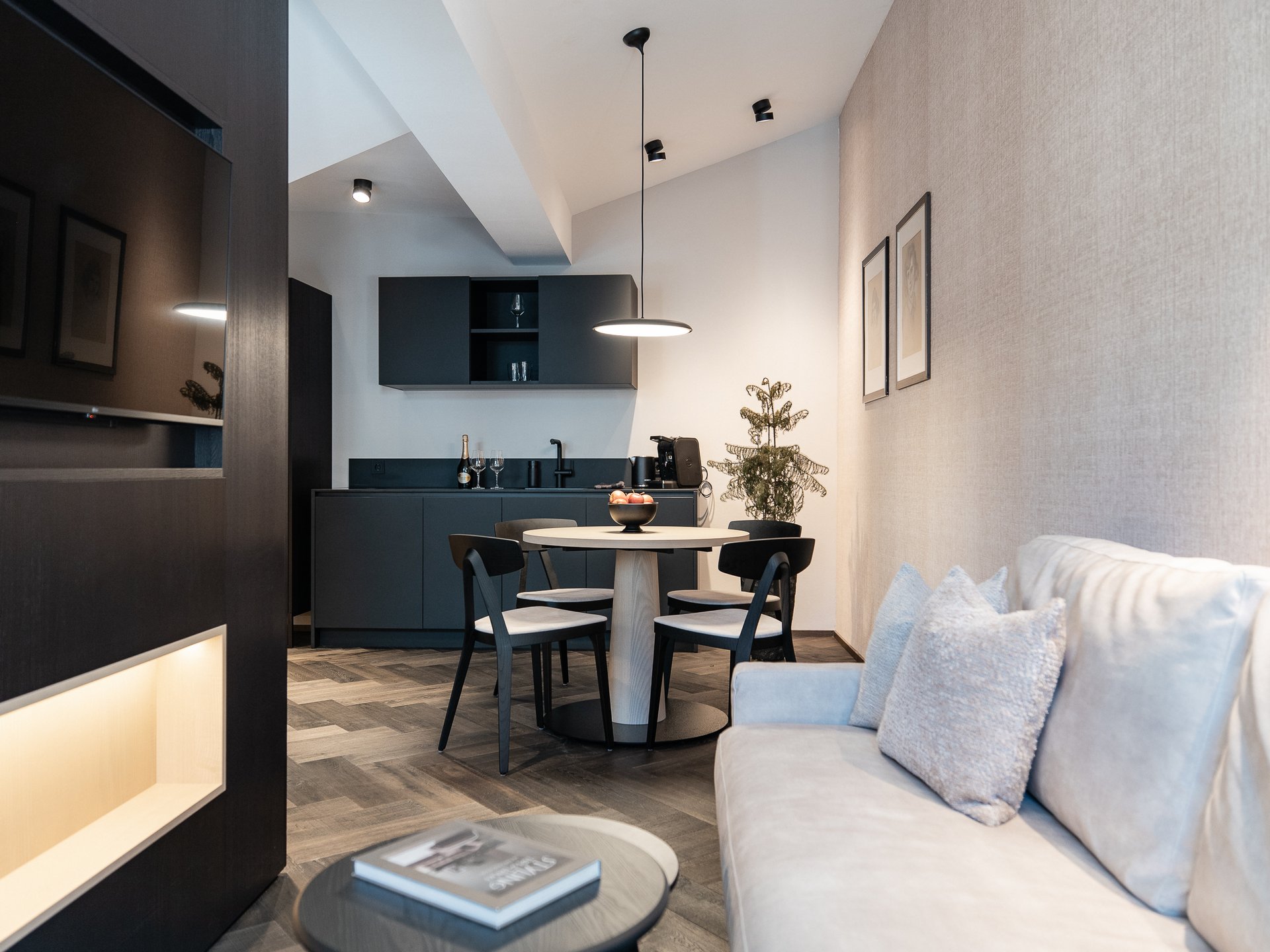 Charmantes Boutique Hotel in Sterzing Moderner Wohnbereich mit Küchenzeile, Esstisch und Sofa mit Kissen