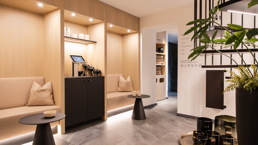 Well-being at the Schwarzer Adler Modern waiting room with beige benches and decorative items