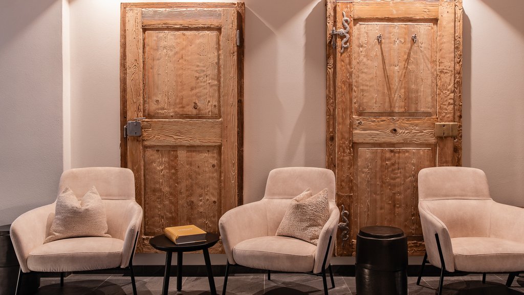 Schwarzer Adler Sterzing: A historic icon. Reinvented. Drei bequeme Sessel vor zwei rustic Holzpaneelen an der Wand