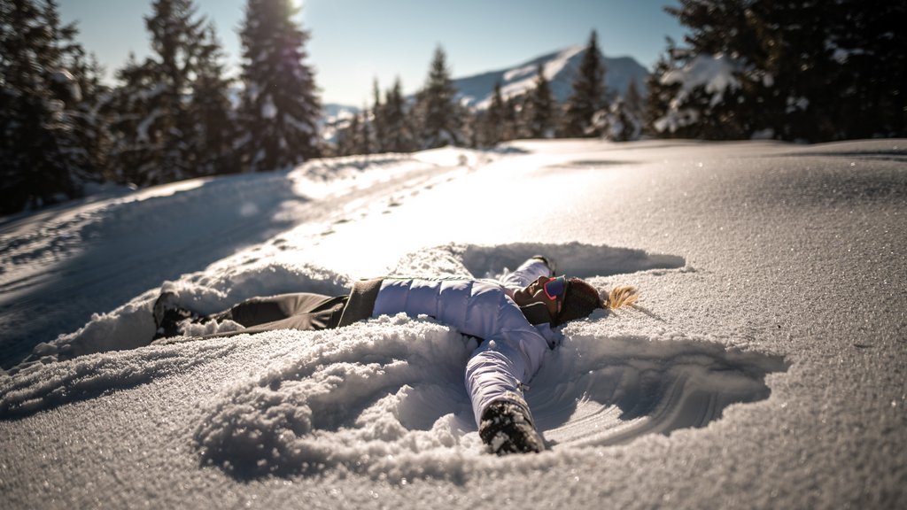 Get your body moving! Person making a snow angel in a snowy mountain winter landscape