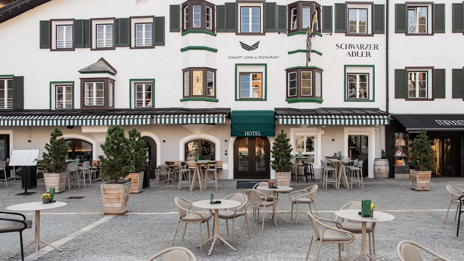 The perfect location for your apartment in Sterzing Exterior view of Schwarzer Adler Hotel with terrace and empty seating area