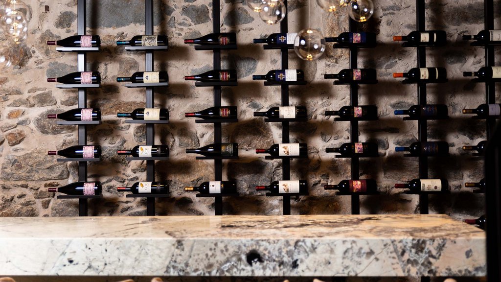 Pamper your palate at this restaurant in Sterzing Wine bottles on modern rack against a stone wall