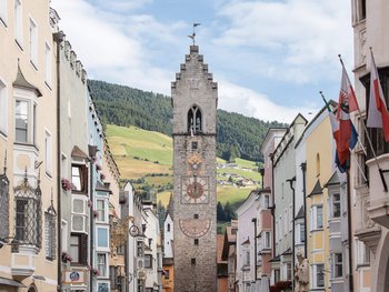 Schwarzer Adler Sterzing: A historic icon. Reinvented. Blick auf den Zwölferturm in Sterzing mit Berglandschaft im Hintergrund