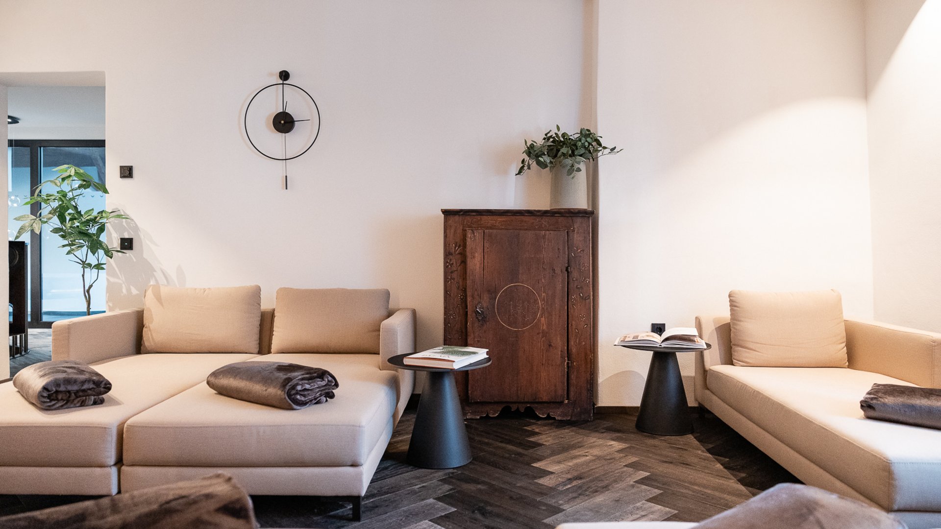 Schwarzer Adler Sterzing: A historic icon. Reinvented. Modernes Wohnzimmer mit beigen Sofas, schwarzen Beistelltischen und Holzboden