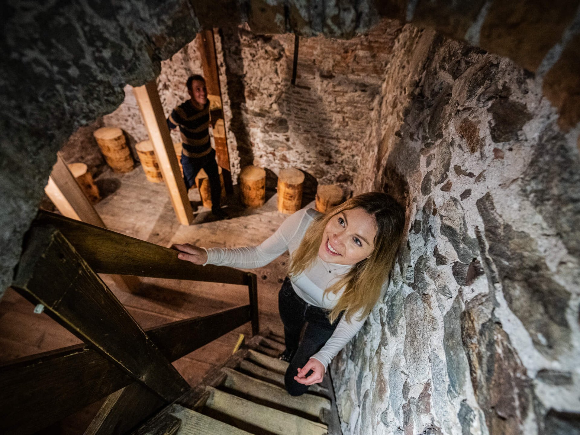 The laid-back town on the Isarco/Eisack river Woman climbing stairs inside a rustic stone-walled house